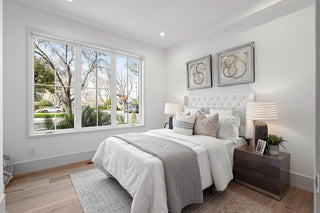 Modern bedroom with large window, bed, and decor