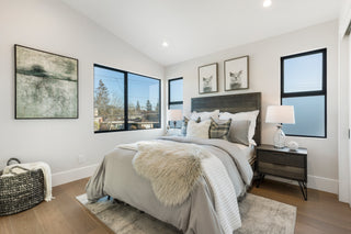 Modern bedroom with large windows, bed, and decor