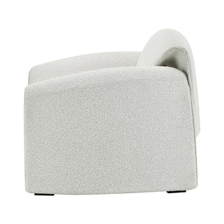 Modern cream textured lounge chair with curved backrest.