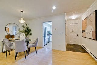 Modern kitchen and dining area with a round mirror, table, and chairs.