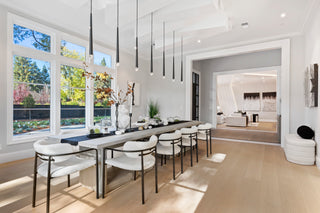 Modern dining area with a long table and chairs in a bright, well-lit room.
