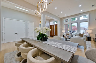 Modern dining room with a long table, chairs, and decorative elements.
