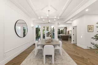 Modern dining room with a rectangular table, six white chairs, and a decorative centerpiece