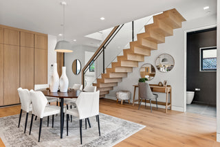 Modern interior with a staircase, dining table, and chairs.