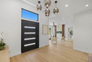 Modern interior with a black door, glass pendant lights, and a view into a living room.