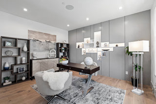 Modern home office with a desk, bookshelf, and decorative items.