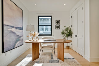 Modern home office with wooden desk, chairs, and decor.