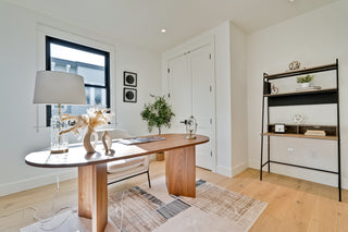 Modern home office with wooden desk, lamp, and decor