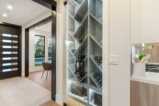 Modern interior with a wine rack, glass door, and kitchen 