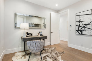 Modern interior with a desk, chair, and abstract art on a white wall.