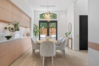 Modern kitchen and dining area with light wood cabinets and white chairs and glass door outlook