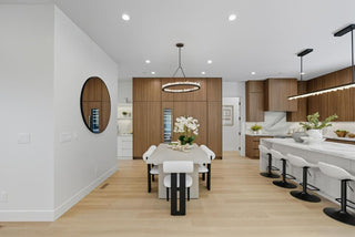 Modern kitchen and dining area with wooden flooring and white walls.