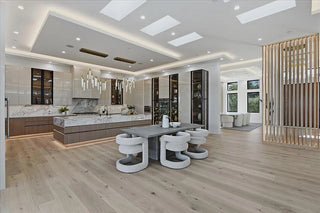 Modern kitchen with marble countertops, stainless steel appliances, and a dining area.