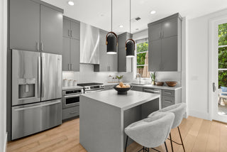 Modern kitchen with gray cabinets, stainless steel appliances, and a white island