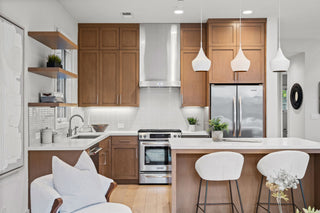 Modern kitchen with wooden cabinets, stainless steel appliances, and white countertops.
