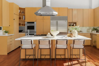Modern kitchen with wooden cabinets, stainless steel appliances, and white countertops.