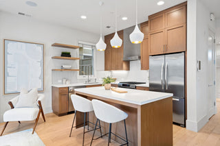 Modern kitchen with wooden cabinets, stainless steel appliances, and white countertops.