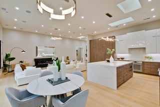 Modern living room and kitchen with white furniture and wooden accents