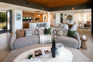 Modern living room with a gray sectional sofa, coffee table, and decorative items.