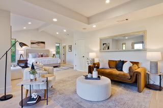 Modern living room with a couch, coffee table, and lamp in a well-lit home.