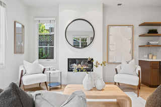 Modern living room with white walls, wooden coffee table, and decorative items.