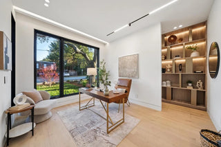 Modern living room with a desk, bookshelf, and large window beautiful nature view