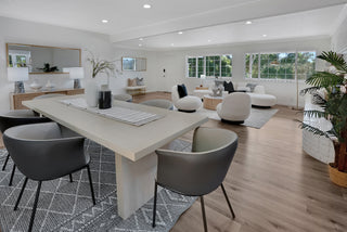Modern living room with a dining table and chairs, and a view of the outdoors.