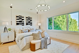 Modern living room with a white sofa, decorative pillows, and large glass windows