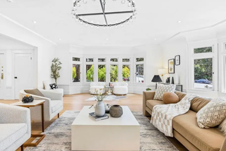 Modern living room with beige sofa, white coffee table, and decorative items.