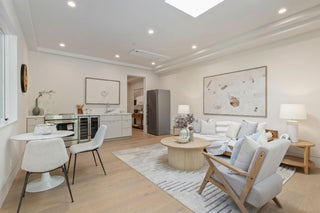 Modern living room with beige sofa, wooden coffee table, and white chairs 