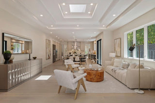Modern living room with beige sofa, wooden coffee table, and white chairs with nice liting 