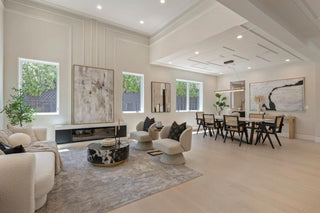 Modern living room with beige sofas, a coffee table, and a dining area with wooden chair with window of glass