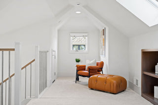 Modern living room with brown leather furniture and abstract art non the wall.