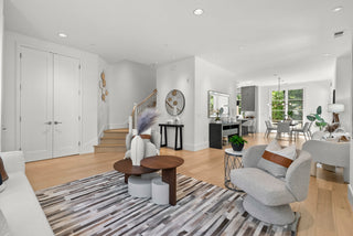 Modern living room with gray sofa, round wooden table, and decorative items with stair