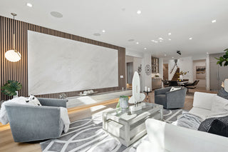 Modern living room with gray sofa, white walls, and decorative elements.