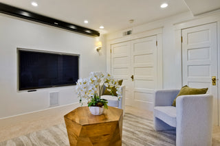 Modern living room with large windows, white sofa, and decorative items.