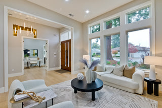 Modern living room with large windows, white sofa, and decorative items.