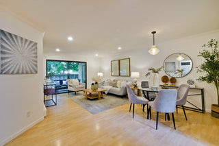 Modern living room with a dining area, featuring furniture and decor.