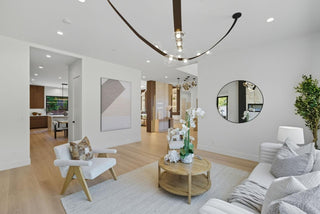 Modern living room with white sofa, armchair, and round coffee table.