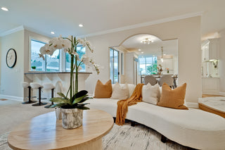 Modern living room with a white sofa, wooden coffee table, and decorative elements.