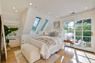Modern living room with white furniture, abstract art, and a fireplace.