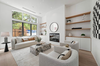 Modern living room with white sofa, armchair, and decorative shelves. with glass window looking nature