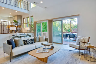 Modern living room with white sofa, coffee table, and decorative pillows.