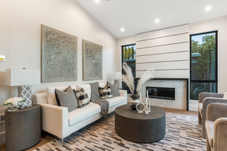 Modern living room with white sofa, decorative pillows, and a fireplace.