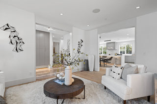 Modern living room with white sofa, wooden coffee table, and decorative elements.
