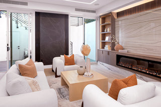 Modern living room with white sofas, orange pillows, and a fireplace two nice glass doors and cute interior design