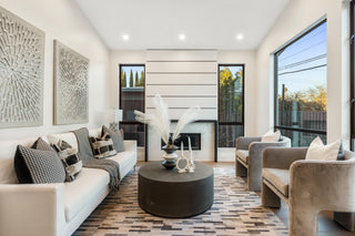 Modern living room with white walls, gray furniture, and decorative elements.