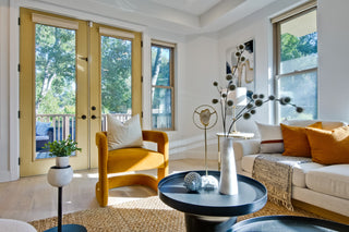 Modern living room with yellow armchair, white sofa, and decorative elements.