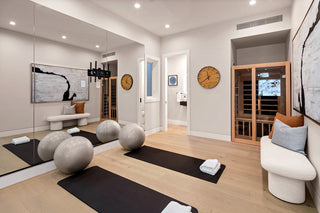 Modern living room with yoga mats on the floor, decorative pillows, and a television show