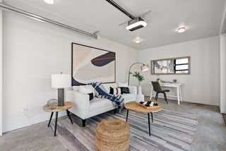 Modern living room with white sofa, coffee table, and decorative items.